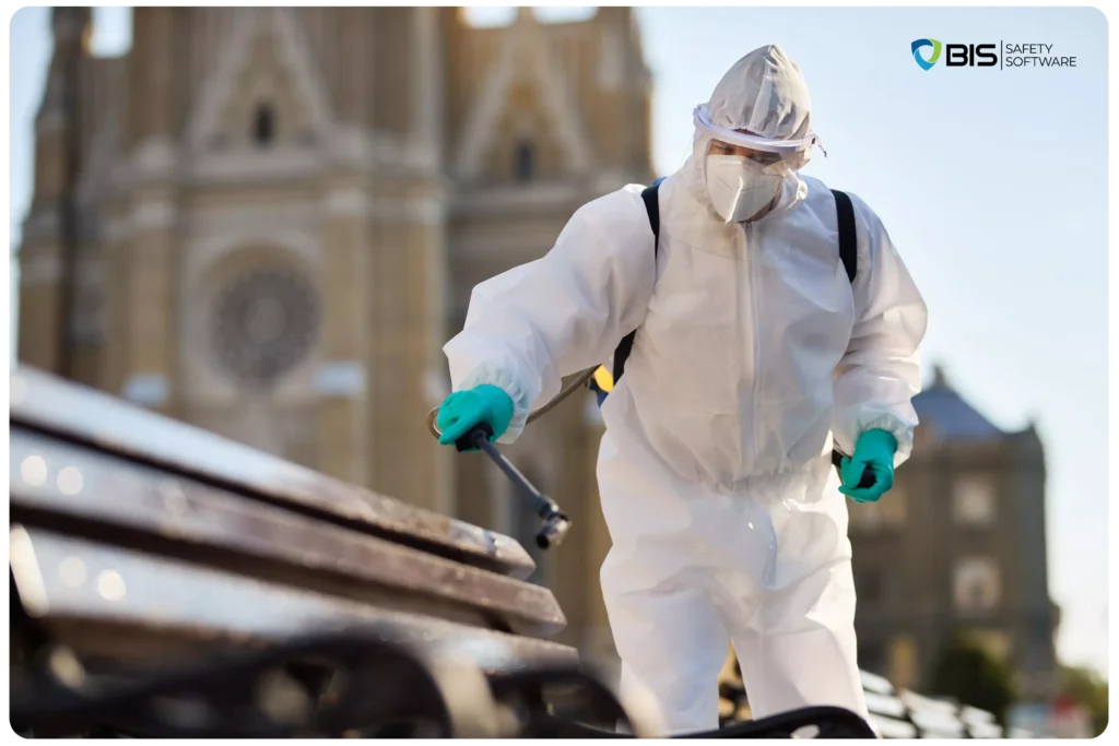 A worker wearing a white HazMat suit, disinfecting the public places.