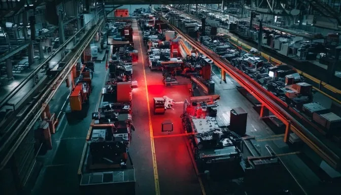 Aerial view of an industrial manufacturing floor with machinery, highlighting areas for nonconformance risk during safety inspections.
