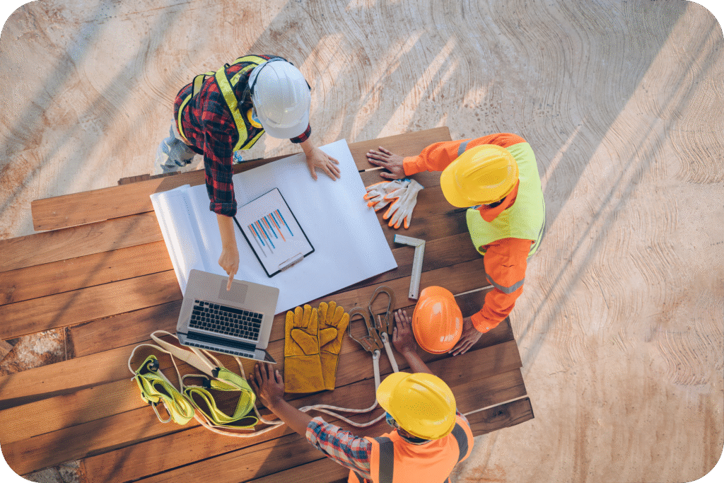 Construction team reviewing project plans on tablet at a building site.