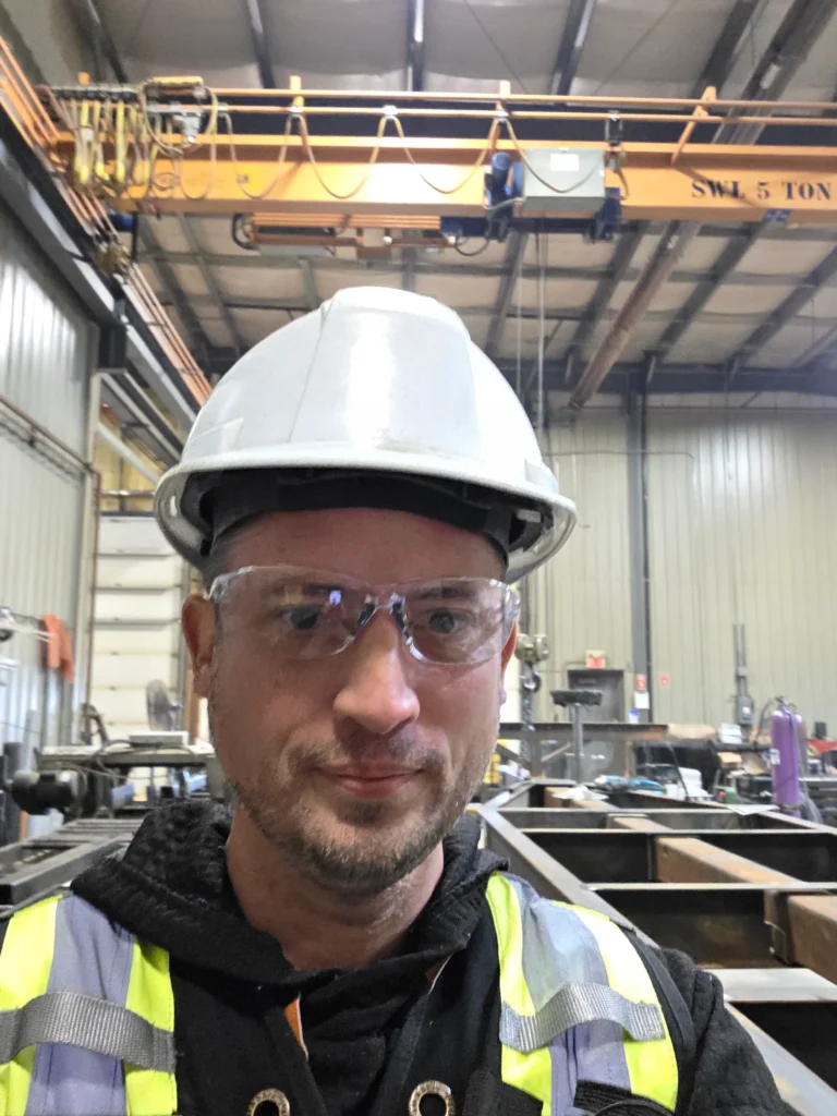 Chris Cole wearing a hard hat and high-visibility vest at an active industrial worksite